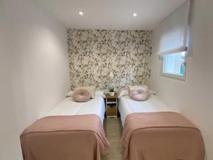 um quarto com duas camas com almofadas cor-de-rosa em Casa del Muelle COMILLAS em Comillas