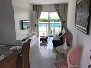 un salon avec un canapé, une télévision et une table dans l'établissement Vg Fun - Frente Mar! No melhor da praia do futuro, à Aquiraz