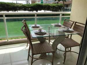 une table en verre avec deux chaises et une table avec des plaques de cuisson. dans l'établissement Vg Fun - Frente Mar! No melhor da praia do futuro, à Aquiraz