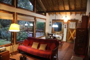uma sala de estar com um sofá e uma mesa em Casa en el bosque de Puerto Manzano em Villa La Angostura