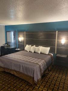 a large bed in a hotel room with two lamps at Faribault Hometown Inn & Suites in Faribault