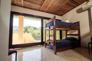 taganga macabi hostel في سانتا مارتا: غرفة نوم مع سرير بطابقين ونوافذ كبيرة