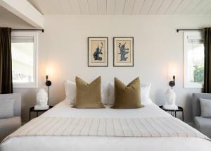 a bedroom with a large white bed and two chairs at Laguna Beach Lodge in Laguna Beach