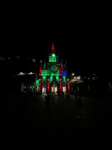 un edificio con una torre dell'orologio illuminata di notte di Apto Av Las Lajas a Ipiales