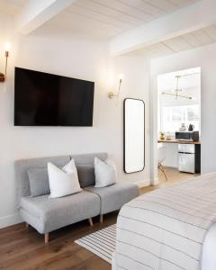 Habitación blanca con sofá y espejo en Laguna Beach Lodge, en Laguna Beach
