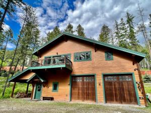 une maison avec un balcon et deux portes de garage dans l'établissement Big Mountain Basecamp, à Whitefish