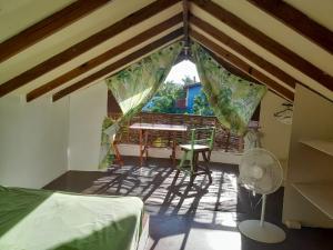 a room with a balcony with a table and chairs at YES PAPA! Rooms at 100m from the beach! in Las Galeras