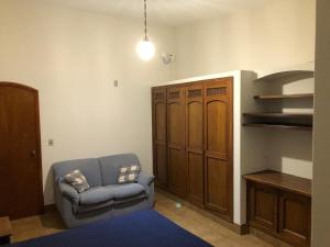 a living room with a blue chair and a cabinet at Recanto Arlecchino in Águas de Lindóia