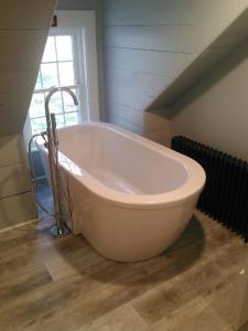 a large bath tub in a room with an attic at Sewall House Yoga Retreat in Island Falls