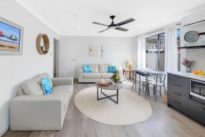 a living room with a couch and a table at Tiarri Terrigal in Terrigal