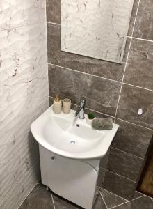 a bathroom with a white sink and a mirror at Luxury apartment 1 Free Underground Parking in Pazardzhik