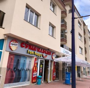 een winkel voor een gebouw met een bord waarop staat "happy market" Ik kan gelukkig zijn. bij Luxury apartment 1 Free Underground Parking in Pazardzhik