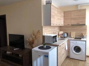 a small kitchen with a washing machine and a microwave at Luxury apartment 1 Free Underground Secure Parking in Pazardzhik