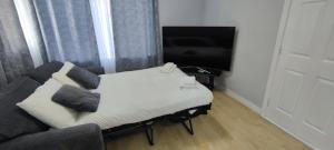 a room with a bed and a couch and a tv at Apartment in the heart of wexford town in Wexford