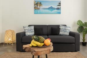 a living room with a couch and a bowl of fruit on a table at Sweet Aloha - Le Mourillon -Host in Toulon