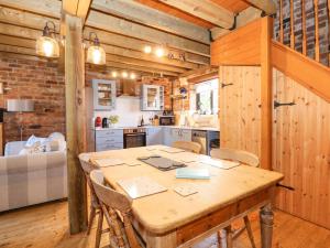 uma cozinha e sala de jantar com uma mesa de madeira e cadeiras em The Dairy Barn em Fakenham