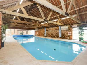 a large swimming pool in a building at The Dairy Barn in Fakenham
