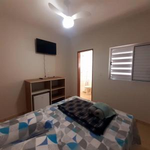 a bedroom with a bed and a ceiling fan at Pousada Nascer da Lua in São Thomé das Letras