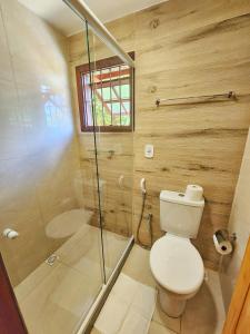 a bathroom with a toilet and a glass shower at Suítes Sunset in Miguel Pereira +28 photos