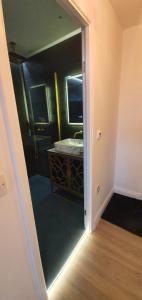 über eine Tür zu einem Bad mit einem Waschbecken und einem Spiegel in der Unterkunft Contemporary Dublin Suite in Lispapple Cross Roads