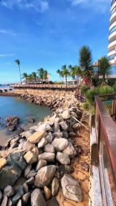 een rotsachtig strand met palmbomen en een gebouw bij Iate Plaza Flat 613 in Fortaleza