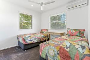a bedroom with a bed and a desk and two windows at Peaceful Family Villa, Sunrise Beach in Sunrise Beach