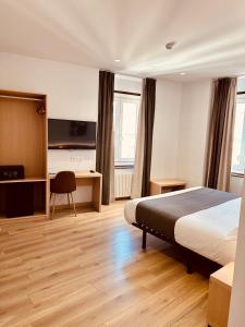 Habitación de hotel con cama y escritorio en Hostal Abadia Madrid en Madrid