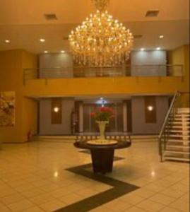 a large lobby with a large chandelier and a table in the middle at Iate Plaza Flat 613 in Fortaleza