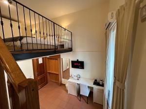 ナポリにあるDayBreak B&Bのデスクと階段が備わる小さな客室です。