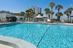 a large swimming pool with palm trees and a building at Bayside at Sandestin #6580 in Destin