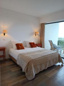 a bedroom with a large bed and a large window at Vinha do Gaio in Monchique