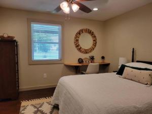 a bedroom with a bed and a mirror and a window at Old Town Bungalow - 4 blocks to Historic Square in Georgetown