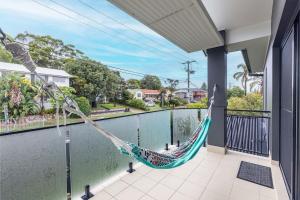 a hammock hanging on a balcony next to a pool at Beach Haven 3a Messines Street 4 Minute walk to the beach Wifi Air Con in Shoal Bay