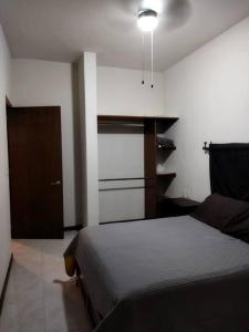 - une chambre avec un lit, un placard et une lampe dans l'établissement Casa totalmente nueva,2 cuartos 2 baños -Muy Segura, à Colima