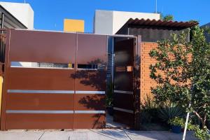 a building with an open door in a yard at Casa totalmente nueva,2 cuartos 2 baños -Muy Segura in Colima