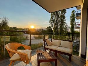 patio z kanapą i krzesłami na balkonie w obiekcie Royal Park Łazienki - Terrace Boutique Apartment w Warszawie