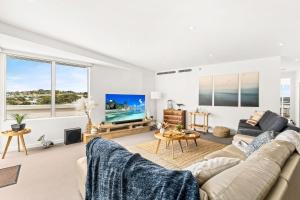 a living room with a couch and a tv at Penthouse Bridgeview San Remo in San Remo