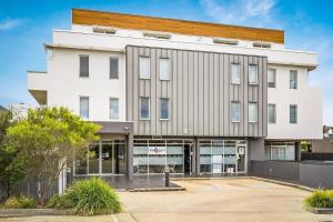 a large white building with a lot of windows at Penthouse Bridgeview San Remo in San Remo