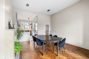 comedor con mesa negra y sillas en Luxurious modern apartment in Antwerp - Breakfast Included, en Amberes