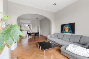 ein Wohnzimmer mit einem Sofa und einem Tisch in der Unterkunft Luxurious modern apartment in Antwerp - Breakfast Included in Antwerpen