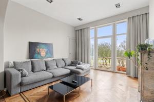 ein Wohnzimmer mit einem Sofa und einem Tisch in der Unterkunft Luxurious modern apartment in Antwerp - Breakfast Included in Antwerpen