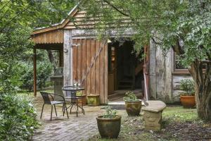een kleine schuur met een tafel en stoelen in een tuin bij Nungaroo Cottage in Bilpin