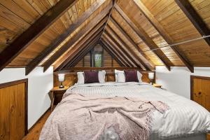 a bedroom with a large bed in a room with wooden ceilings at NUNGAROO COTTAGE in Bilpin