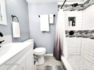 a white bathroom with a toilet and a shower at Studio 3! in Lakeland