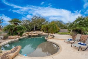 una piscina en un patio trasero con sillas y árboles en 1 Acre 5 Bedroom 1 Den Custom Home with Private Pool Hot tub Sport Court in Luxury Neighborhood en Scottsdale