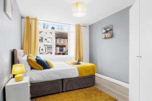 1 dormitorio con 1 cama con cortinas amarillas y ventana en Cosy 2 Bedroom Ground Floor Apartment with Garden - Coventry, en Coventry