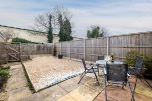 a patio with a table and chairs and a fence at Cosy 2 Bedroom Ground Floor Apartment with Garden - Coventry in Coventry