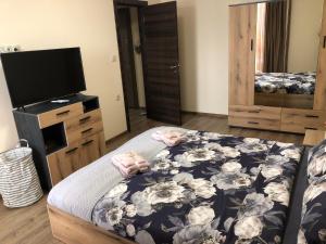 a bedroom with a bed and a flat screen tv at Luxury apartment 2 Free Underground Parking in Pazardzhik