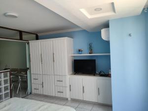 a living room with white cabinets and a television at Atlântico Flat -207- Vista ao Mar e Pé na Areia in Natal
