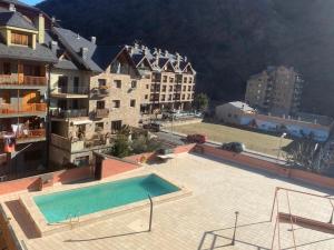 a swimming pool in the middle of a building at Apartamento dúplex acogedor con piscina en Rialp in Rialp
